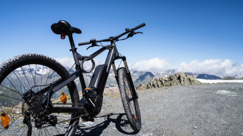 E-bike on a mountain trail with clear sky and peaks in the background