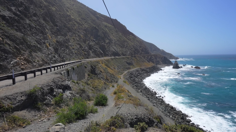 A winding coastal highway hugs cliffs above the Pacific Ocean, one of the top Road Trip Stops in the Western U.S.