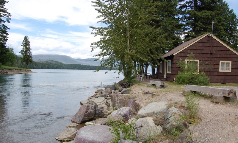 Glacier Park Cabin by the lake surrounded by pine trees