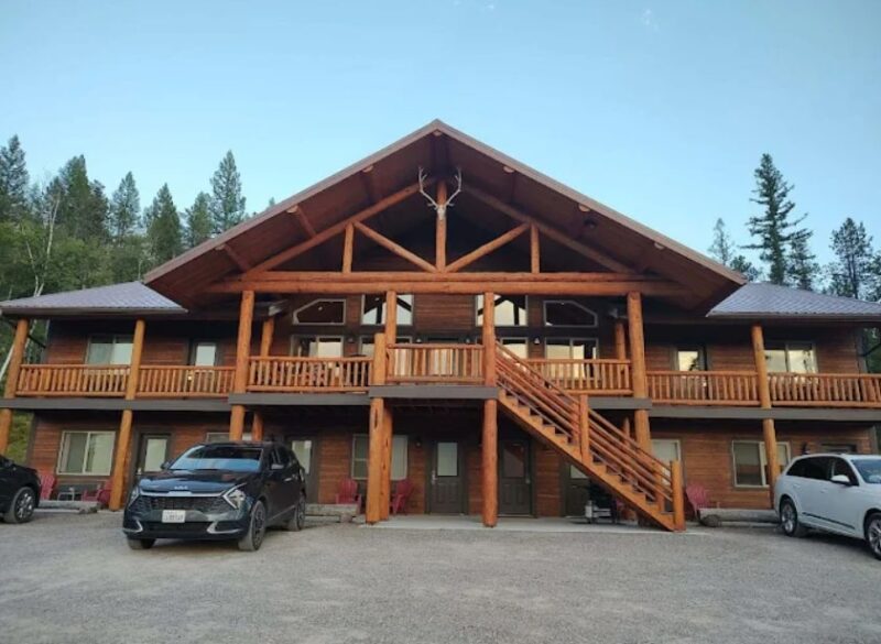 Large Glacier Park Cabin lodge with balcony and parked cars