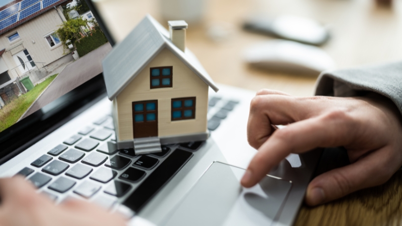 Person browsing real estate listings on a laptop showing how Americans can buy property abroad