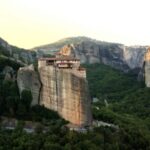 A monastery on a cliff in Meteora, Greece, offering a peaceful summer escape in Europe