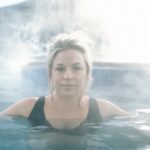 A woman relaxes in a steaming pool at a natural hot springs in Montana during winter
