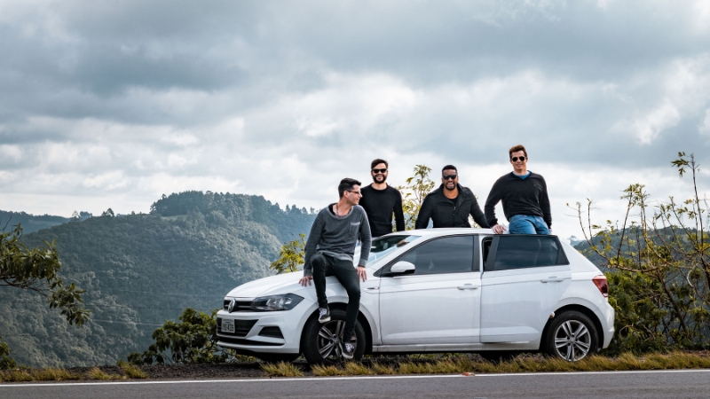 Four friends on a guys trip in Montana with a white car on a mountain road