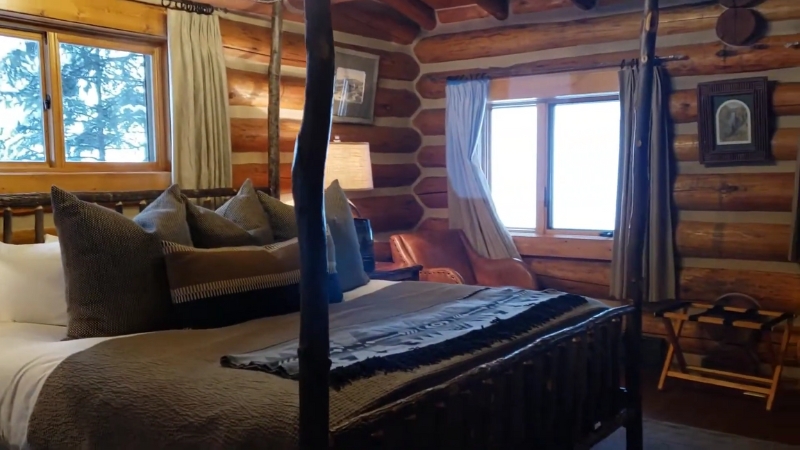 Cozy log cabin bedroom with rustic decor at Lone Mountain Ranch in Big Sky, Montana