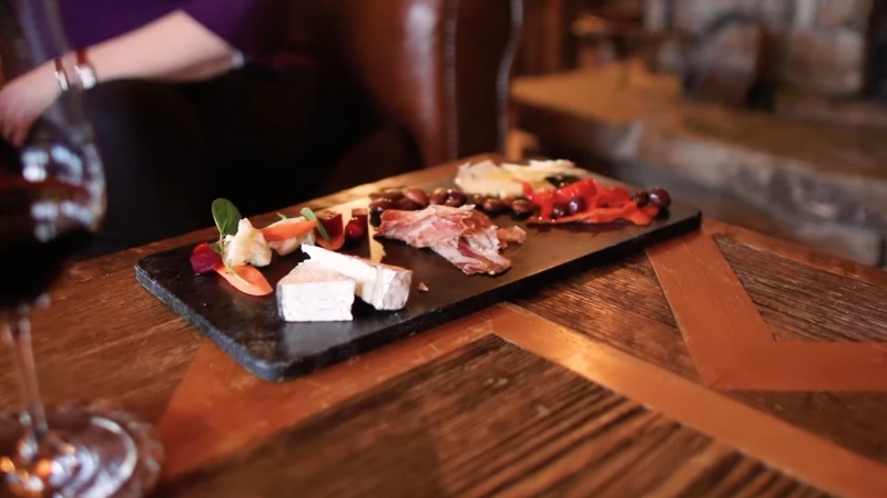 Charcuterie board with wine served by a cozy fireplace during romantic fine dining in Montana