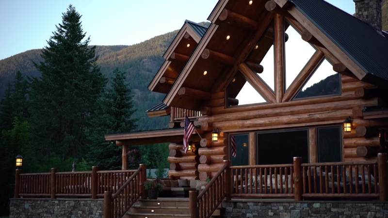 Log cabin surrounded by trees and mountains