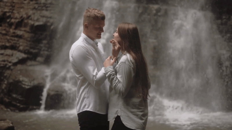 Couple standing close by a waterfall at one of the top romantic destinations in Montana