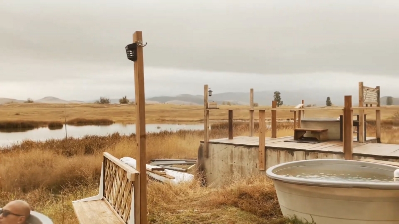A man soaks in a round tub at Wild Horse Hot Springs in Hot Springs, Montana