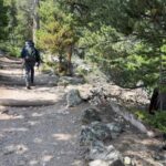 Backpacker on a rocky forest path in Montana on one of the state’s hidden hiking trails