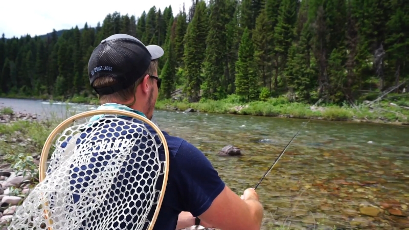 A man fishes along a clear mountain river in the Bob Marshall Wilderness