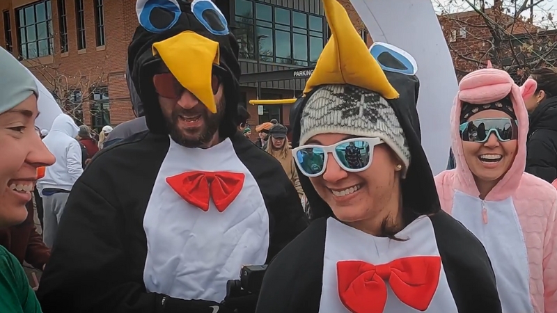 Runners dressed in penguin costumes smile before the start of the Smithfield Turkey Trot in Utah