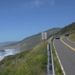 Cars on a coastal highway with ocean views, showing one of the top scenic road trip destinations in the U.S.