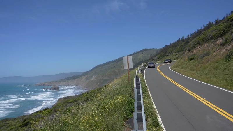 Cars on a coastal highway with ocean views, showing one of the top scenic road trip destinations in the U.S.