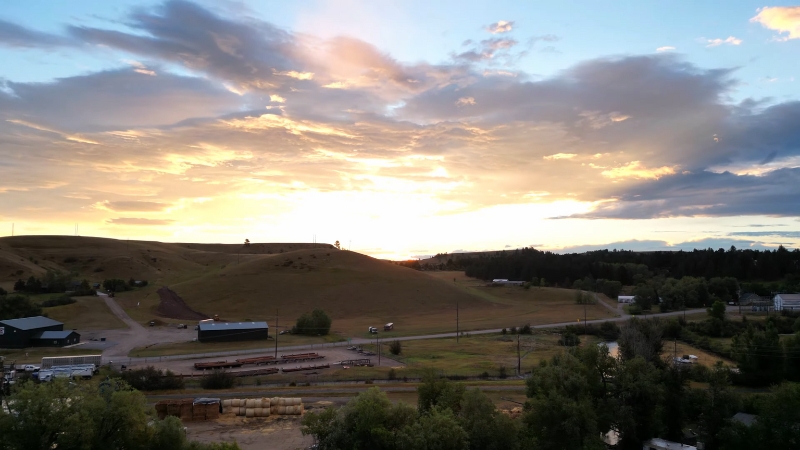 A peaceful sunrise over open hills and small farms near Lewistown that reflects the appeal of affordable Montana locations