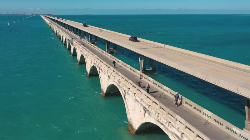 Cars drive along the Overseas Highway bridge over turquoise water in the Florida Keys
