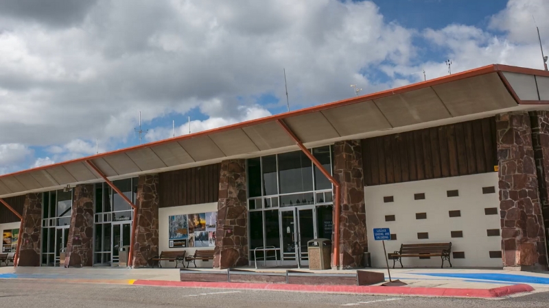 Yellowstone Airport WYS shown with its stone pillars and main entrance under a wide roof