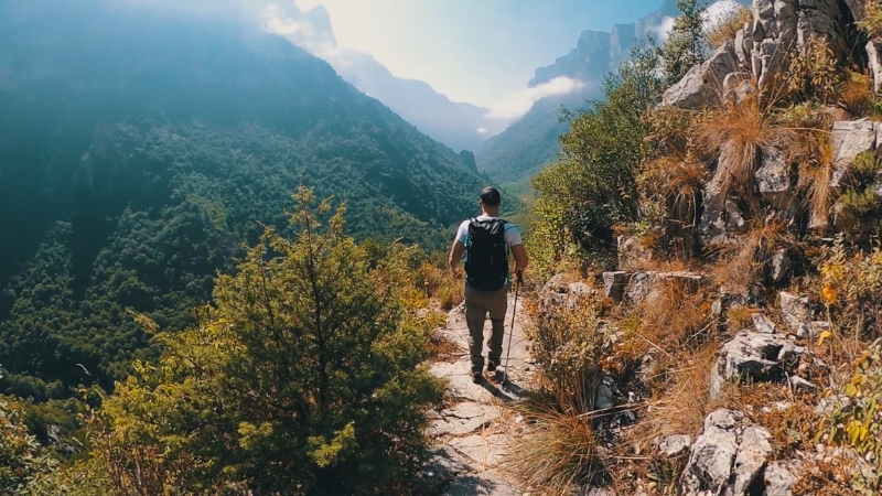 Hiker walking along a mountain path in one of the best hiking destinations in Europe