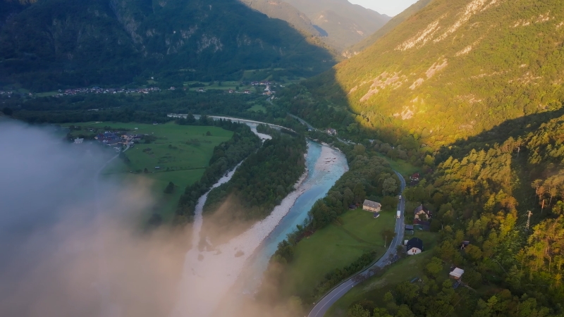 Aerial view of the Soča River winding through a green valley in Slovenia