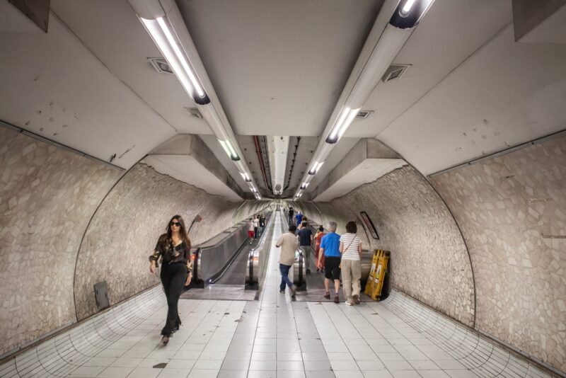 People using an underground transit system with escalators in a foreign city