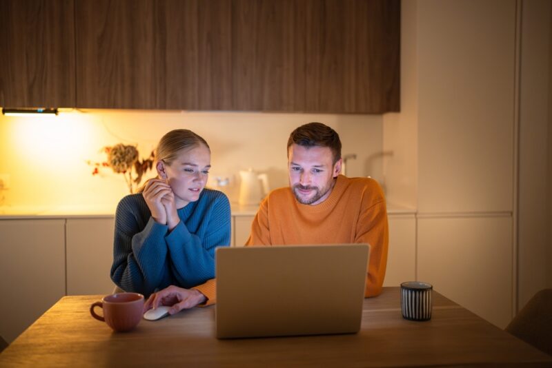 Couple reviewing booking details on a laptop before traveling