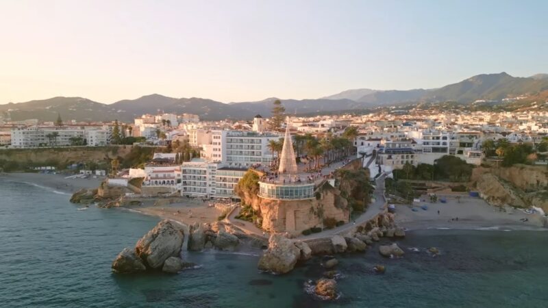 A coastal town with beaches, palm trees, and mountains beside the sea